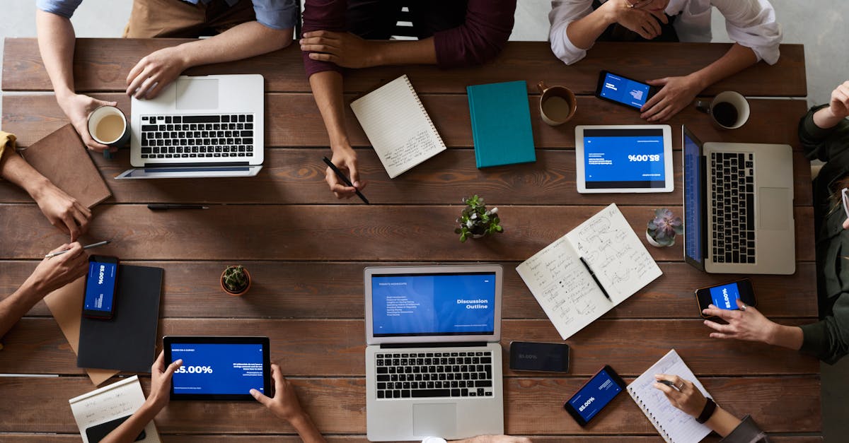 pexels-photo-3183150-3183150 Overhead view of a diverse team in a business meeting using laptops and tablets.
